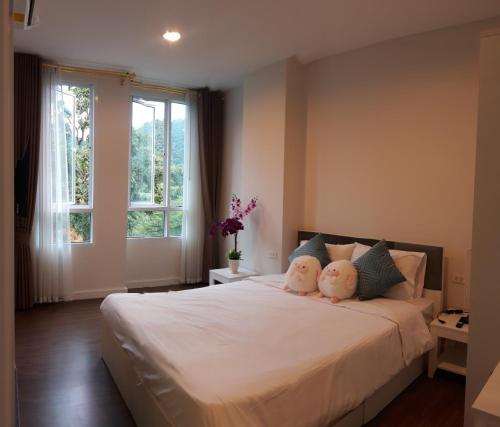 a bedroom with a bed with two teddy bears on it at Courtyard khaoyai by August in Khao Yai