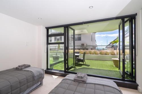 a bedroom with a bed and a large window at ELEVEN APARTMENT in Tauranga
