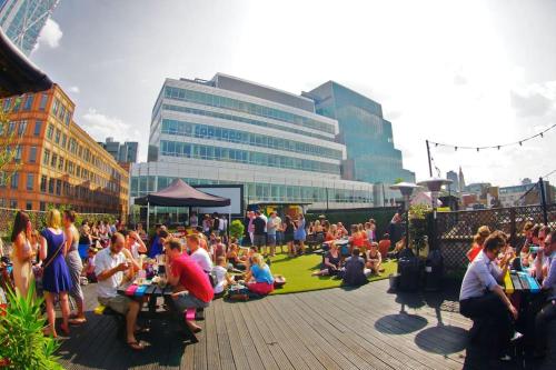 a crowd of people sitting on a boardwalk in a city at GORGEOUS FlatC Central London Liverpool St Station in London