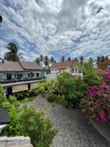 a garden with flowers in front of a house at Catsen Bungalows & Pool Phan Thiet in Phan Thiet