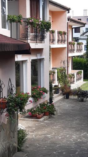 a building with potted plants on the side of it at Motivi Hotel in St. St. Constantine and Helena