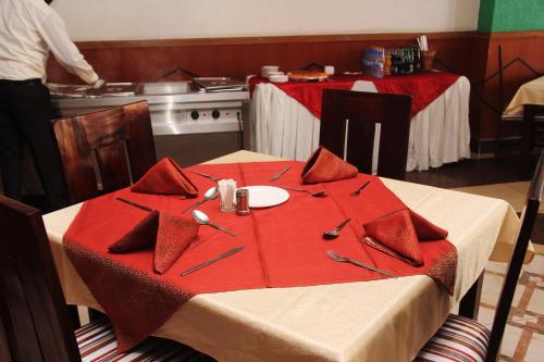 a kitchen with a table with a red table cloth at Hotel Winstar in Eldoret