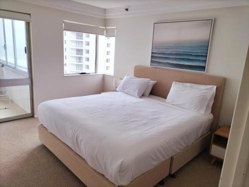 1 dormitorio con 1 cama blanca grande y ventana en Marriner Views, en Gold Coast