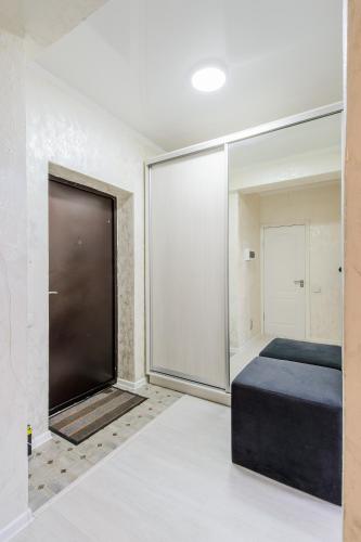 a bedroom with a bed and a large glass wall at Appartments " Zhetysu-4" in Almaty