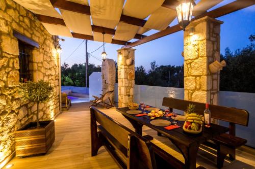 a dining room with a table on a patio at Villa Diamante -Seafront Stone Villa for 5 with Stunning Sunset Views By Villa Mana Gers in Amoudi