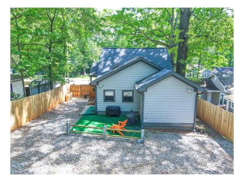 a small house with a green yard next to a fence at Lovely 3BR 3BA Home minutes from Airport/Downtown Atlanta in Atlanta