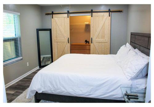 a bedroom with a large white bed and a sliding door at Lovely 3BR 3BA Home minutes from Airport/Downtown Atlanta in Atlanta