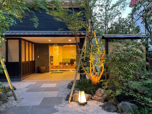 a house with a garden with a light in the yard at Hotel Fukudaya in Tokyo