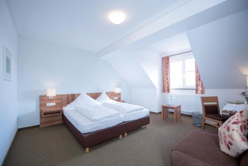1 dormitorio con 1 cama, 1 silla y 1 sofá en Weingut Kernwein, en Seinsheim
