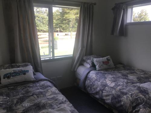 a bedroom with two beds and a window at Fairway views B & B in Matamata