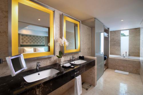 a bathroom with two sinks and a large mirror at Sovereign Bali Hotel in Kuta