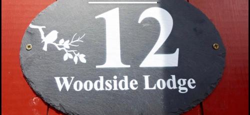a sign with the number woodisode lodge at Woodside Lodge in Thurstaston