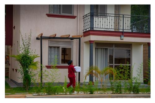a woman walking in front of a building at Nataaha Hotels in Mbarara