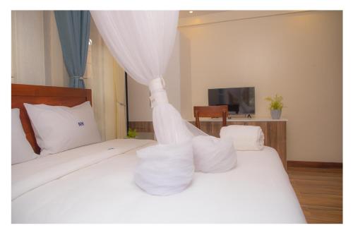 a bedroom with two beds with white pillows at Nataaha Hotels in Mbarara