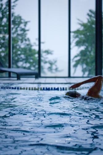 a person swimming in a swimming pool with windows at China Fleet Country Club in Saltash