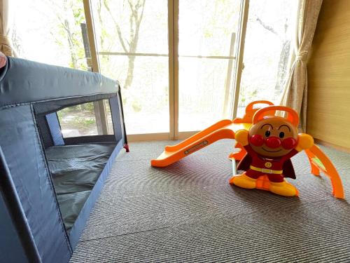 a toy dog sitting on the floor next to a play tent at HOKUTO SATOYAMA BASE in Hokuto
