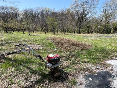 a generator sitting on the grass in a field at HOKUTO SATOYAMA BASE in Hokuto