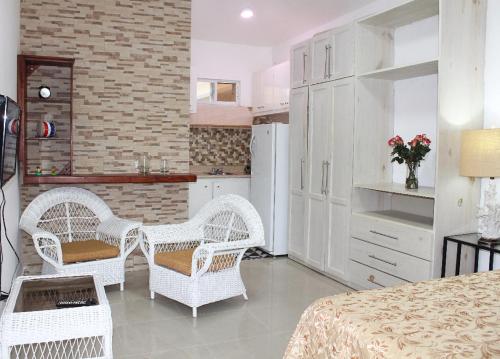 cocina con mesa y sillas blancas de mimbre en Fully Equipped 1br Studio –dt–2mins To The Beach, en Sosúa