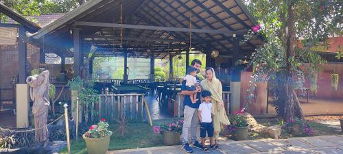 a family standing in front of a house at Kuruva Island Resort And Spa - By KABINI BREEZE in Mananthavady