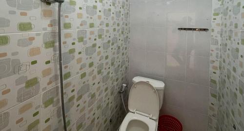 a small bathroom with a toilet in a stall at Valencia Homestay Redpartner in Parapat