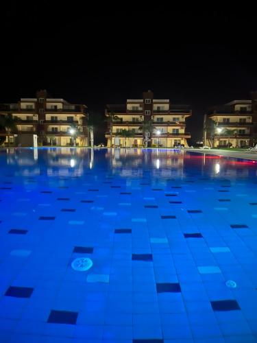 a swimming pool at night with buildings in the background at Royal Sun in Iskele