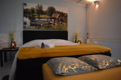una camera da letto con un grande letto con due cuscini di BenB de Walvis a Krimpen aan de Lek