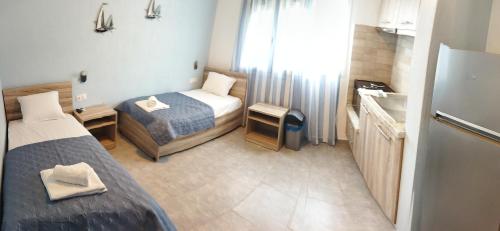 a small room with two beds and a refrigerator at STUDIOS KOULA 2-DIMOS in Potos