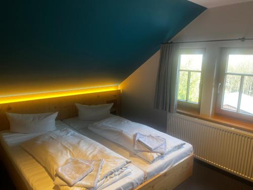 a bed with white sheets and pillows in a bedroom at Berghotel Pöhlberg in Annaberg-Buchholz