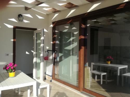 a room with a glass door with benches and tables at Terra Sinus Beautiful Suite in Terrasini