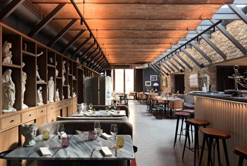 ein Restaurant mit Tischen, Stühlen und Holzdecken in der Unterkunft Paradis Pietrasanta in Pietrasanta