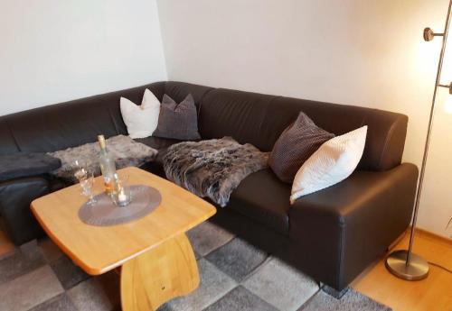 ein schwarzes Sofa mit Kissen und einem Tisch im Wohnzimmer in der Unterkunft Haus "Panorama" in Hohenau