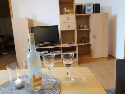 eine Flasche Wein und zwei Gläser auf dem Tisch in der Unterkunft Haus "Panorama" in Hohenau