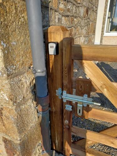 a wooden gate with a thermostat on a building at Maison Face au Mont avec extérieur in Avranches