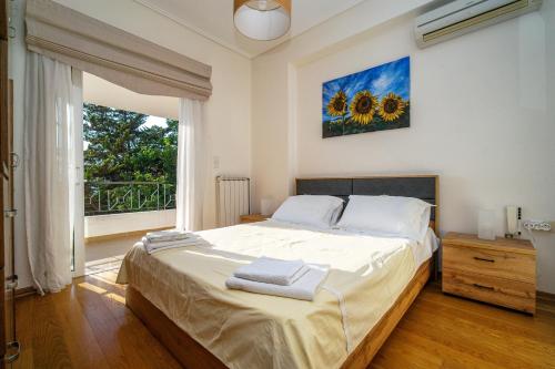 a bedroom with a large bed and a large window at VILLA ELENI in Anavissos