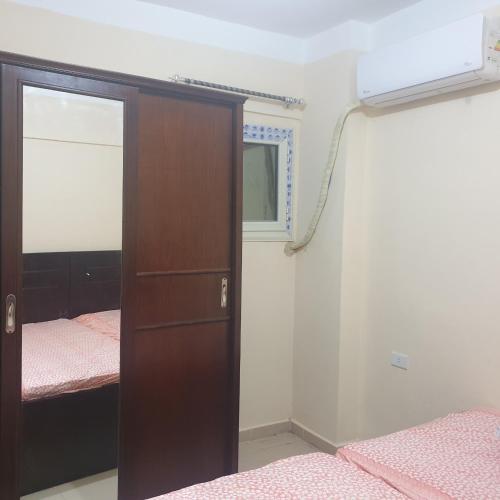 a bedroom with a closet and a bed and a mirror at شاليه للعائلات غرفة وريسيبشن بمنتجع ريتال فيو الساحل الشمالى in El Alamein