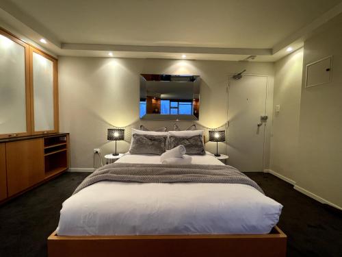 a bedroom with a large bed and a window at KOZYGURU McMahons Point Amazing Water View Studio + FREE Parking NMP002 in Sydney