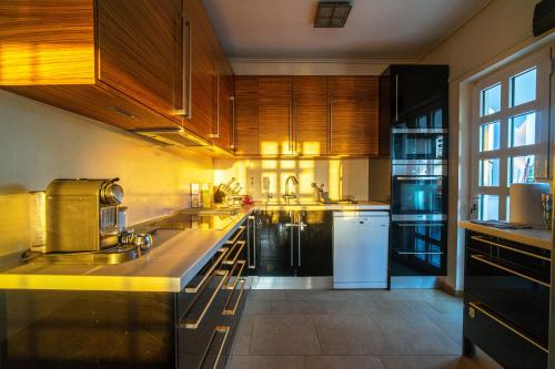 a large kitchen with wooden cabinets and white appliances at VILLA ELENI in Anavissos