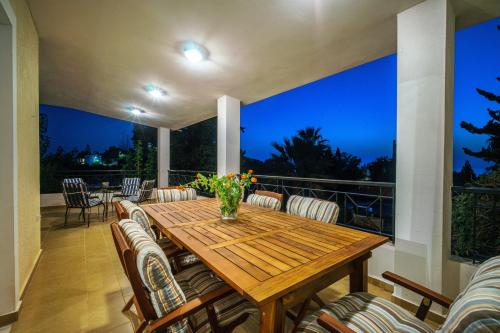 a patio with a wooden table and chairs at VILLA ELENI in Anavissos