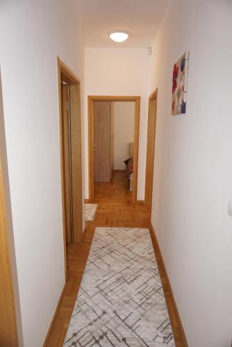 a hallway with white walls and a rug at Vila Sarajevo 4 in Sarajevo