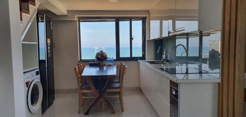 uma cozinha com uma mesa e vista para o oceano em Aries Hotel em Tuy Hoa