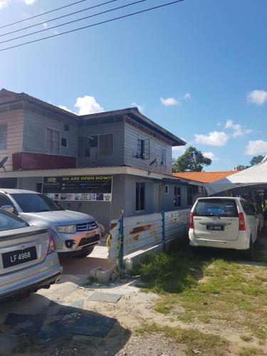 a parking lot with cars parked in front of a house at Orchid Roomstay in Labuan