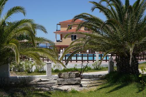 un resort con palme e un edificio sullo sfondo di Vitoratos Studios a Lixouri