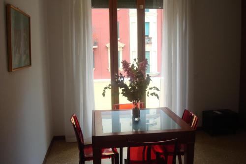 a dining room table with chairs and a vase with flowers at Apartment Bruno's in Rome