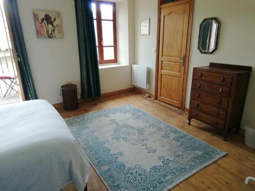 sypialnia z łóżkiem, komodą i dywanem w obiekcie Aux douces nuits de Rivel w mieście Rivel