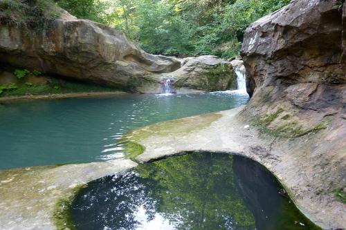 uma cascata numa piscina de água junto a um rio em Aux douces nuits de Rivel em Rivel