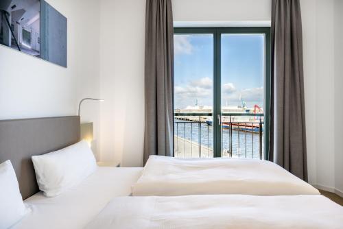 - une chambre avec un lit et une vue sur l'océan dans l'établissement Krusespeicher Krusespeicher 3-50, à Wismar
