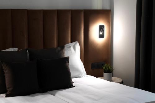 Schlafzimmer mit einem weißen Bett mit einem Kopfteil aus Holz in der Unterkunft Bayer's City Hotel in München