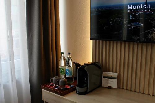 a table with bottles of wine and a television at Bayer's City Hotel in Munich