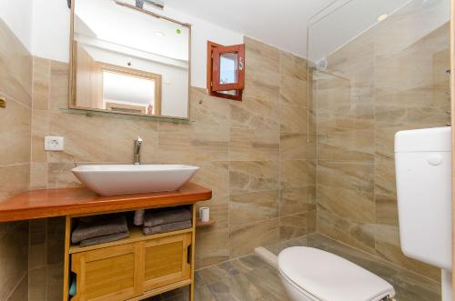 a bathroom with a sink and a toilet and a mirror at House Frane in Drvenik Mali