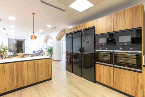 a large kitchen with wooden cabinets and a kitchen island at Residencia Demar in Godella